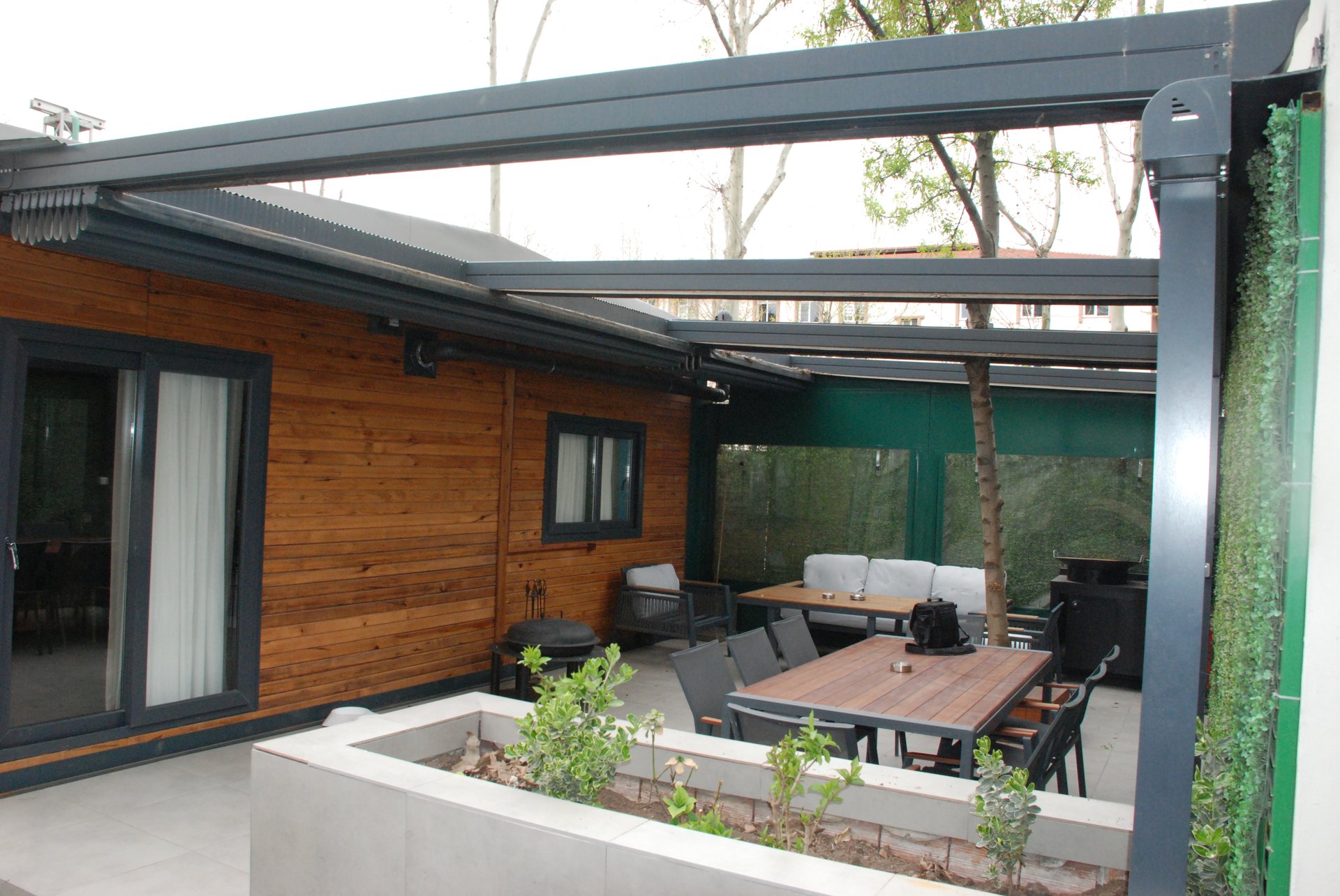 Aynı teras, motorlu pergola tentenin kumaş çatısı açıkken